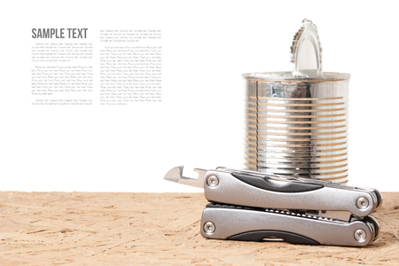 tin opener and opened tin on wooden desk