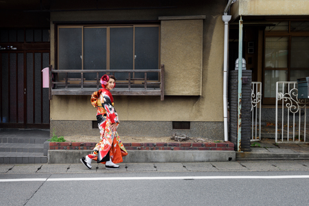 KYOTO, JAPAN - NOVEMBER 05, 2014: Unidentified japanese lady dressed in kimono walking on street.のeditorial素材
