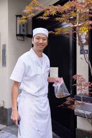TOKYO, JAPAN - NOVEMBER 03, 2014: Unidentified japanese chef gathering maple leaves from tree to decorate the food.のeditorial素材