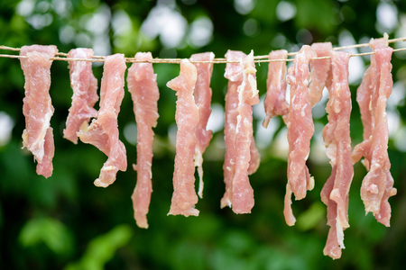 Strips of pork drying in the sunの写真素材