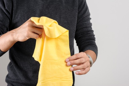 yellow PVA chamois for car cleaning in man's handの写真素材