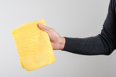 yellow PVA chamois for car cleaning in man's handの写真素材