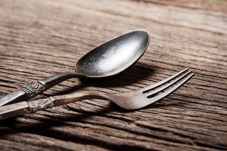 dinning table with old brass spoon and forkの写真素材