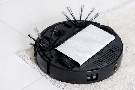 closeup dusting paper under robotic vacuum cleanerの写真素材