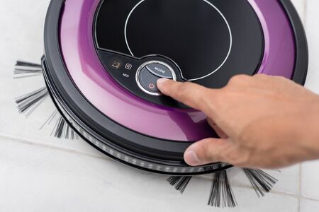 the man using robotic vacuum cleaner to clean his roomの写真素材
