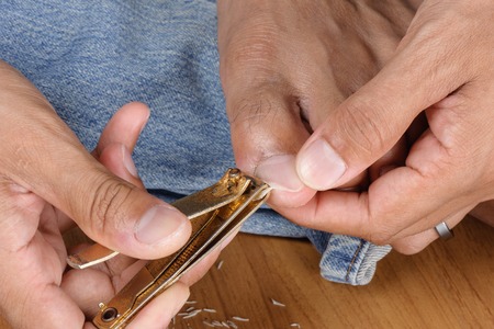Adult man trimming his toenails with nail clipper.の写真素材