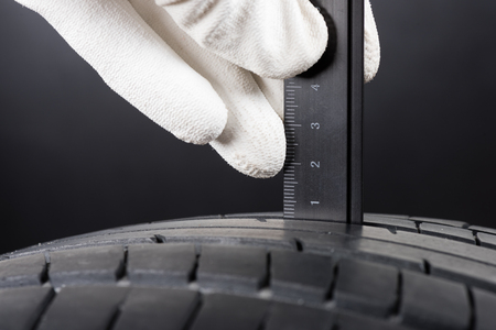 checking the depth of car tire treadの写真素材