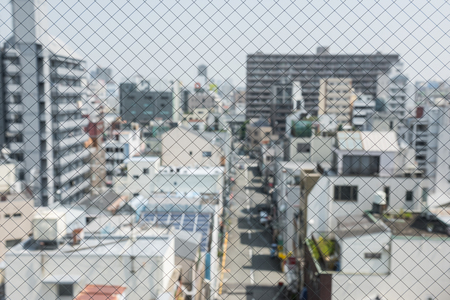 closeup safety wired glass with view of city in Japan (shallow depth of field).の写真素材