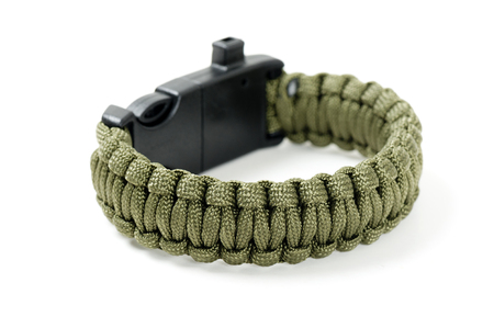 green multifunction paracord survival bracelet over white backgroundの写真素材