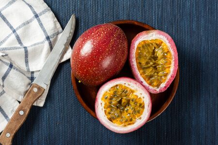 Fresh passion fruit on the desk. Passion fruit contains many small black seeds covered with the fruit's flesh.の写真素材