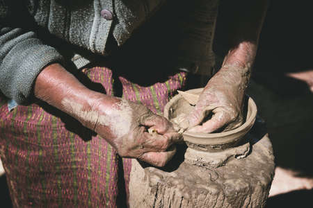 closeup old woman potter hands making bowl from clay, without potter's wheelの写真素材