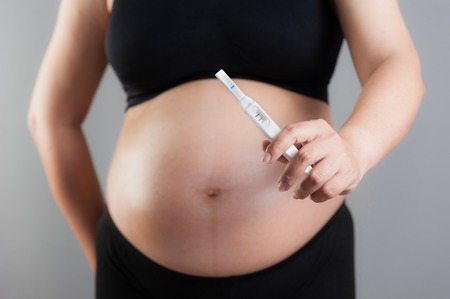 closeup pregnancy test in pregnant woman's handの写真素材