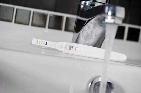 closeup pregnancy test with positive pregnant (low light and shallow depth of field)の写真素材