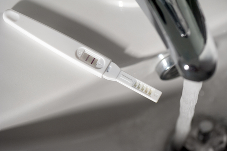closeup pregnancy test with positive pregnant (low light and shallow depth of field)の写真素材