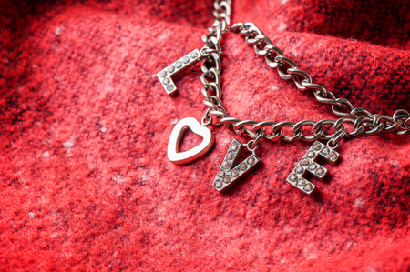 abstract the word love from woman accessory (metal chain, heart shaped and diamonds)の写真素材