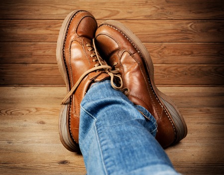 man in jeans wearing old brown leather shoesの写真素材