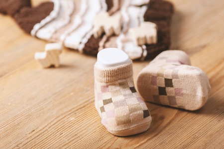 new baby socks on wooden board, newborn and baby concept, shallow depth of fieldの写真素材