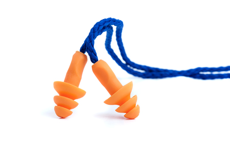 Orange reusable ear plugs over white background, personal safety equipmentの写真素材