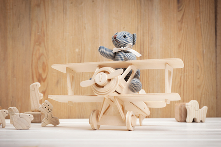 Cute teddy bear on wooden background with wooden baby toysの写真素材