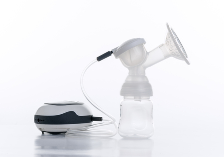 Breast pump and blank baby bottle isolated over white backgroundの写真素材