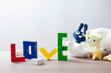 colorful wooden puzzle blocks toy, wooden construction blocks with geometric shapes. the word loveの写真素材