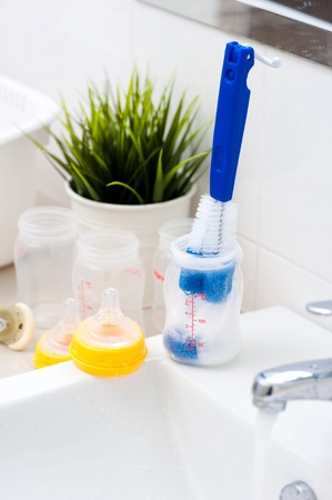 washing baby bottles and nipples with soft bottle brush and dishwashing liquidの写真素材