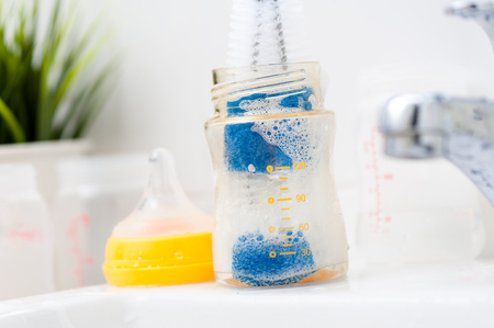 washing baby bottles and nipples with soft bottle brush and dishwashing liquidの写真素材