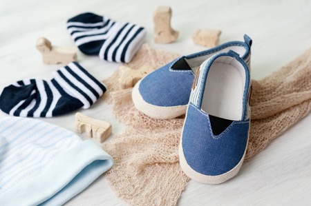 closeup little shoes for baby over white wooden backgroundの写真素材