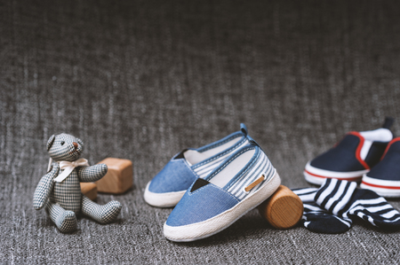 closeup little shoes and socks for baby over fabric backgroundの写真素材