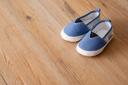 closeup little shoes for baby on wooden deskの写真素材