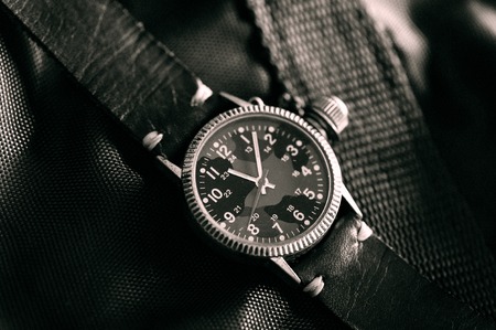 old military or field style of wristwatch with camouflage dial and leather band. (black and white...