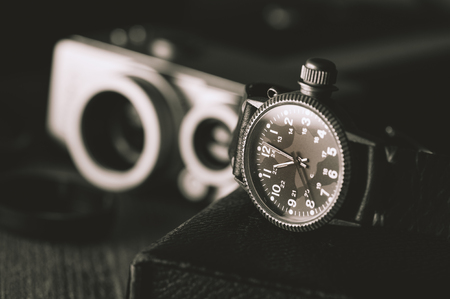 old military or field style of wristwatch with camouflage dial and leather band.
