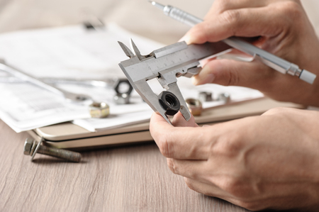 measuring the dimensions of part with metal vernier caliper, vernier caliper is a measuring instrument used to precisely measure linear dimensions.の写真素材