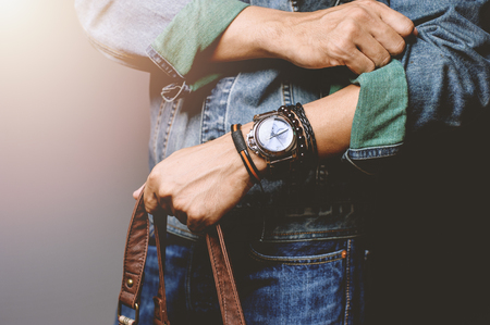 The man in jean jacket wearing bracelets and wristwatch, casual style of men accessories. Shallow depth of field.の写真素材