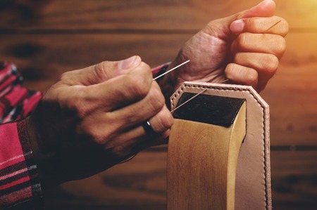 Sewing the vegetable tanned leather by hand. Leather and the craft tools.の写真素材