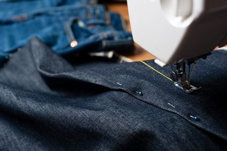 sewing indigo denim jeans with sewing machine, garment industrial concept.の写真素材