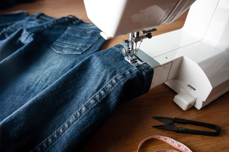 sewing indigo denim jeans with sewing machine, garment industrial concept.の写真素材