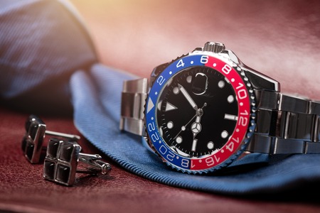 closeup luxury wristwatch for men with black dial blue-red bezel and stainless steel bracelet.の写真素材