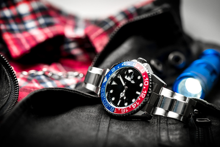 closeup luxury wristwatch for men with black dial blue-red bezel and stainless steel bracelet.の写真素材