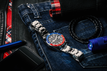 men's accessories, closeup at wristwatch with black dial blue-red bezel and stainless steel bracelet.の写真素材