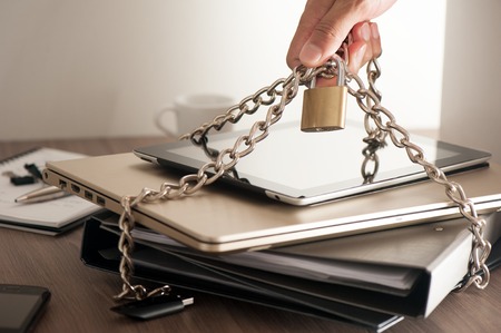 important information locked with chain and padlock, computer and data security concept.の写真素材