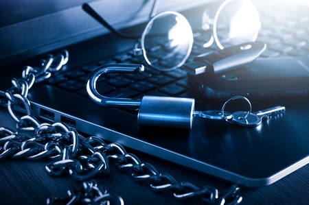 laptop with chain and unlocked padlock, computer and data security concept.の写真素材