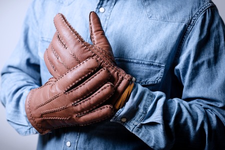 A man wearing the brown leather gloves in winter.の写真素材