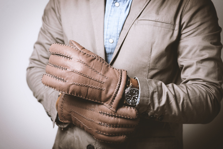 A man wearing the brown leather gloves in winter.の写真素材