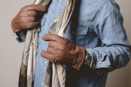 A man wearing the brown leather gloves in winter.の写真素材