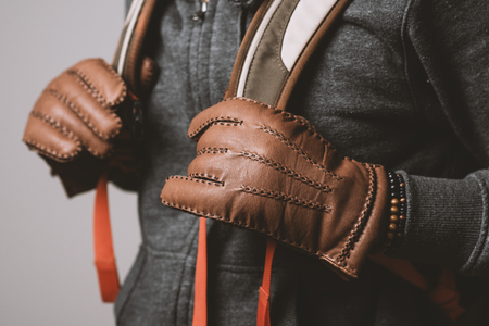 A man wearing the brown leather gloves in winter.の写真素材