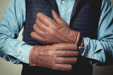 A man wearing the brown leather gloves in winter.の写真素材