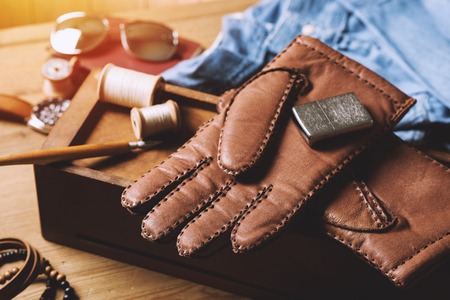 Pair of men's brown leather gloves and other men's accessories.の写真素材