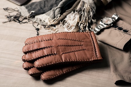 Pair of men's brown leather gloves and other men's accessories.の写真素材