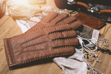Pair of men's brown leather gloves and other men's accessories.の写真素材